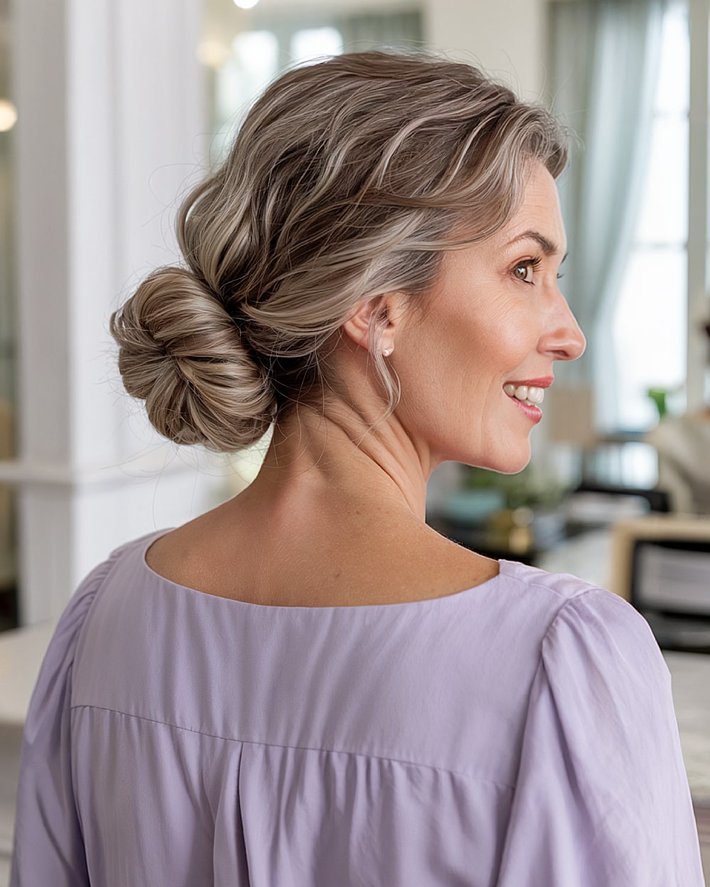 Easy updo with twisted low bun on medium-length wavy gray-blonde hair, perfect for mature women