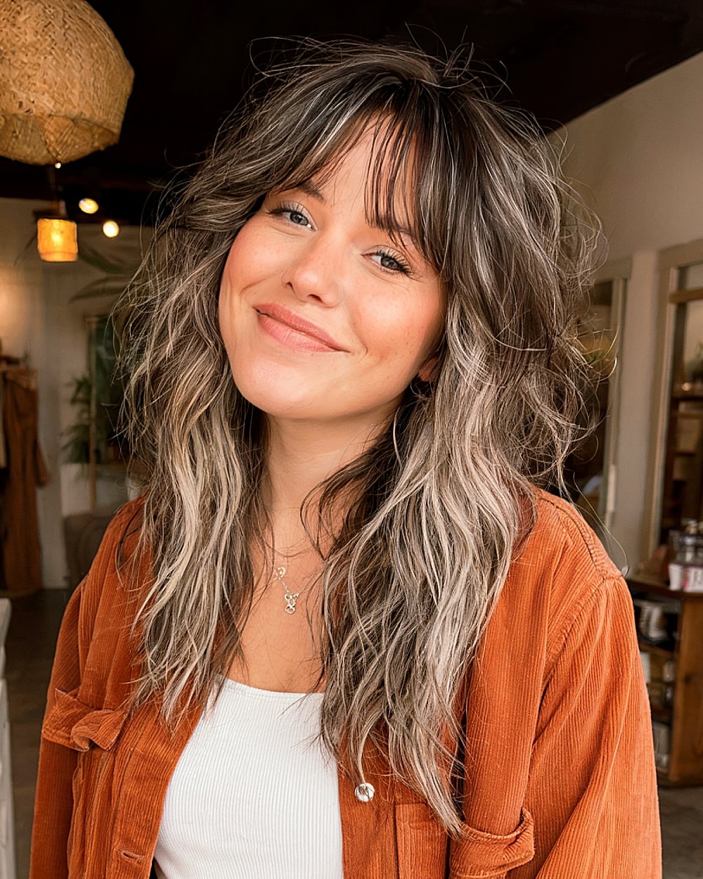 Wavy wolf cut with layered texture, curtain fringe, and bold face-framing highlights for long hair